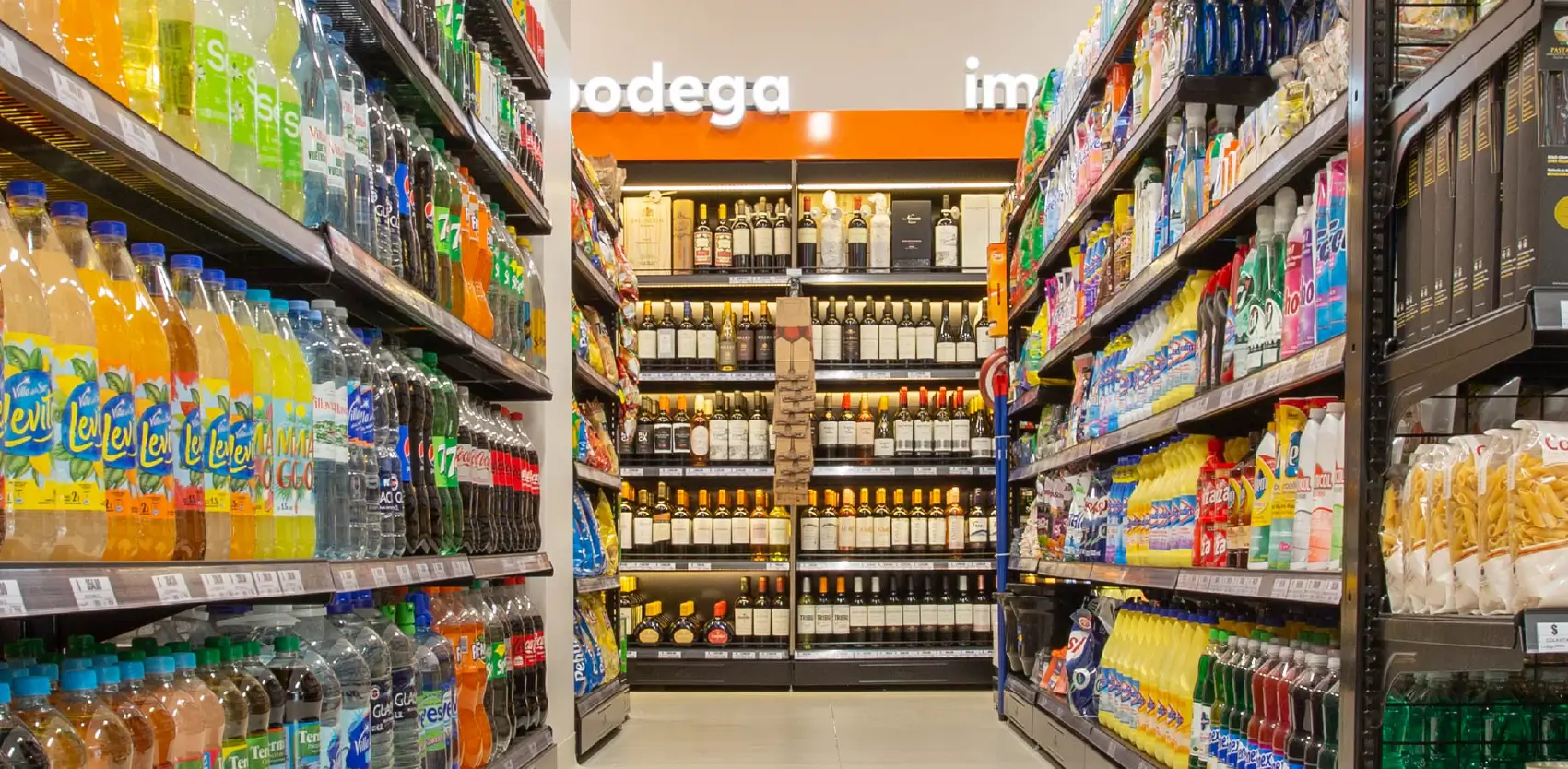 Sector de vinoteca en supermercado argentino con góndolas metálicas para bebidas premium