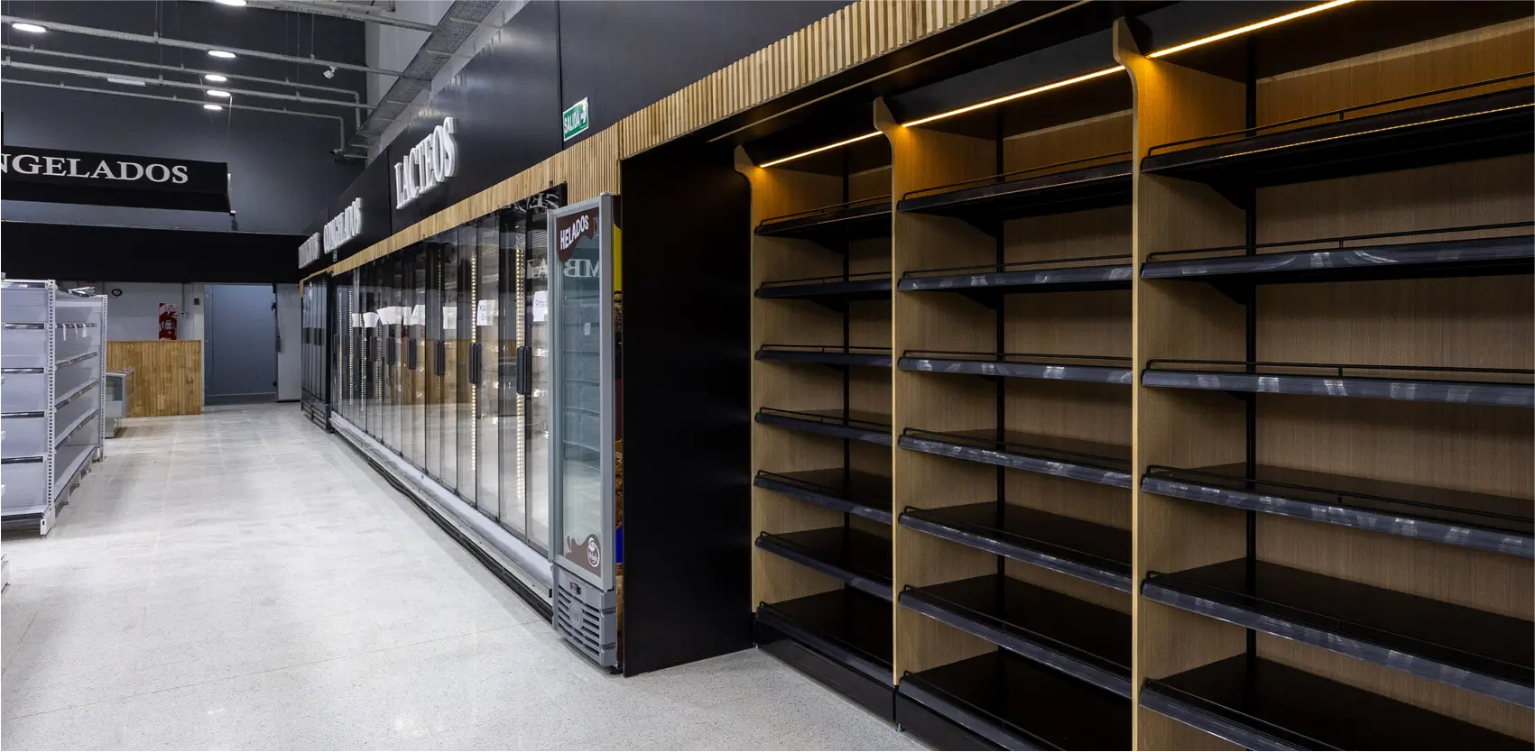 Góndolas metálicas Moduace instaladas junto a heladeras en supermercado, diseño moderno y lineal optimizado